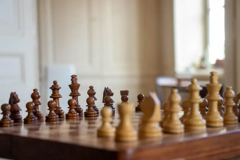A tight close-up of brown wooden chess pieces on the board, evoking tactical combinations.